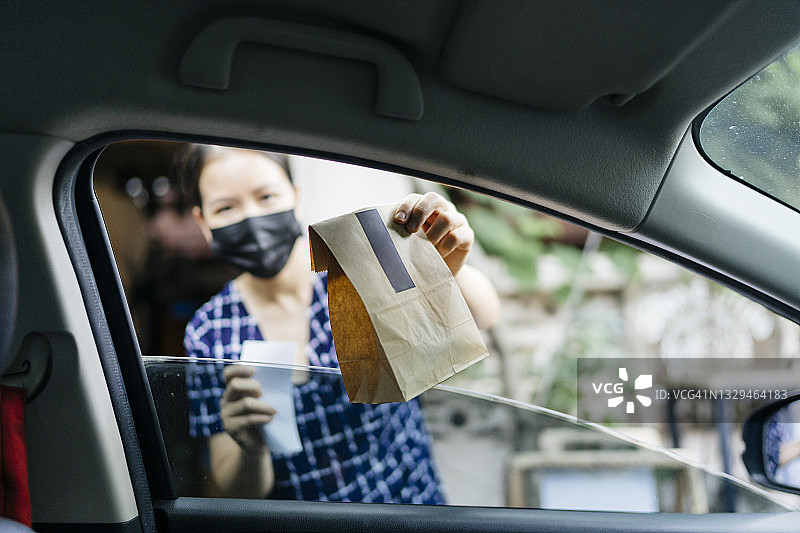 疫情期间，女性店主餐厅为送货司机提供披萨的个人视角图片素材