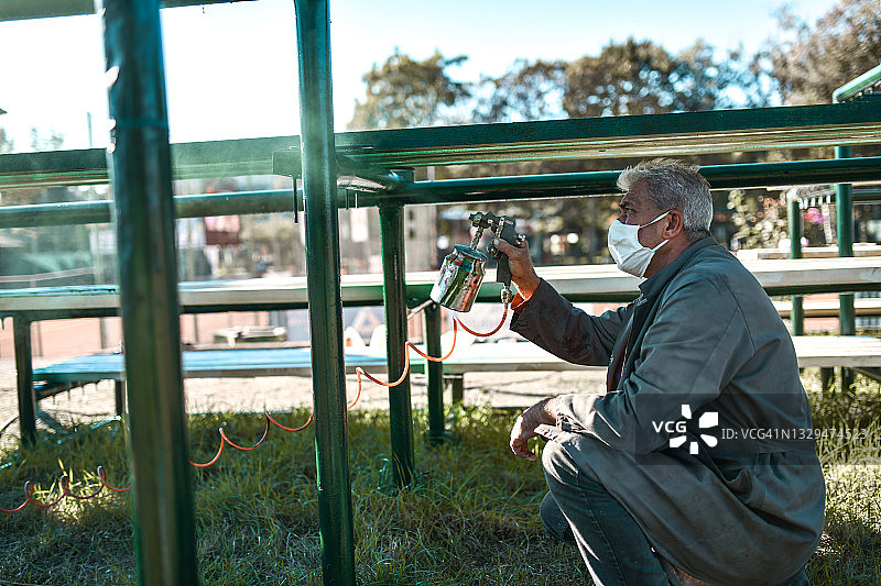 专注喷漆看台的年长男性画家图片素材