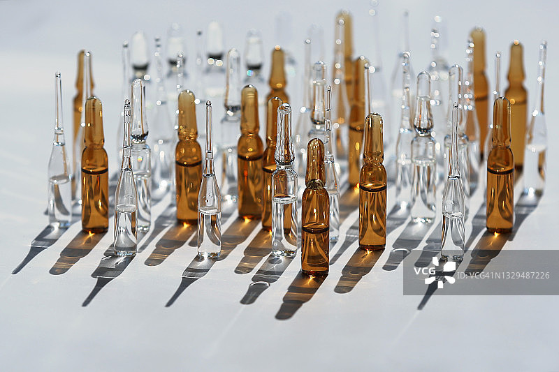 阳光阴影背景上的白色古铜色透明安瓿瓶合集图片素材