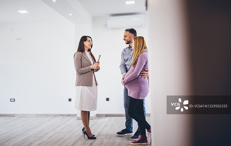 情侣从房地产经纪人那里得到他们新家的钥匙图片素材
