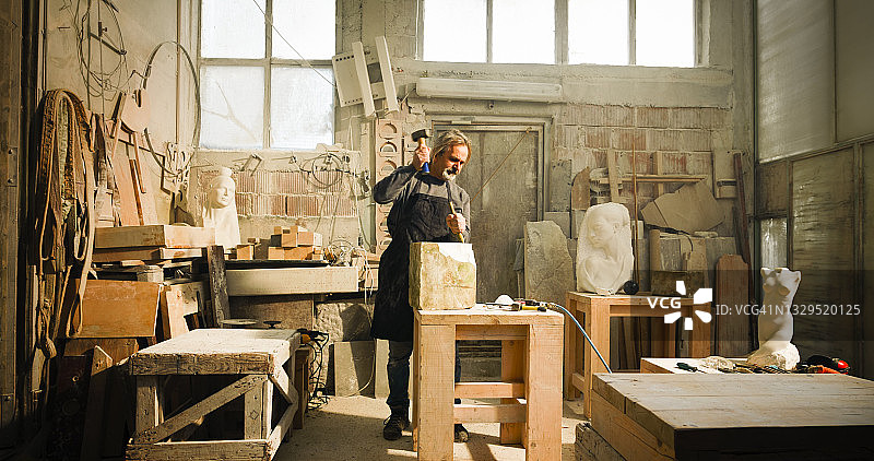 石匠在工作室凿石头图片素材