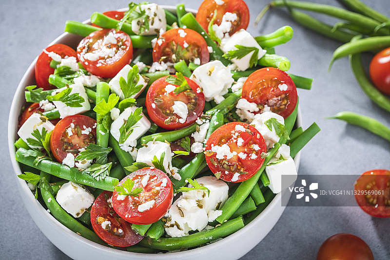 含有圣女果、绿豆、菲达奶酪和欧芹的地中海健康沙拉碗图片素材