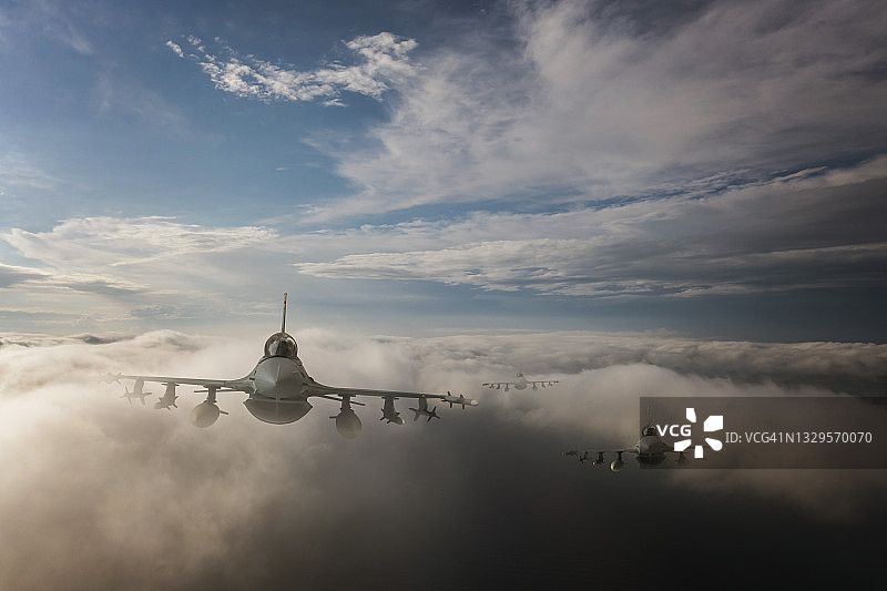 喷气式战斗机飞过云层。图片素材