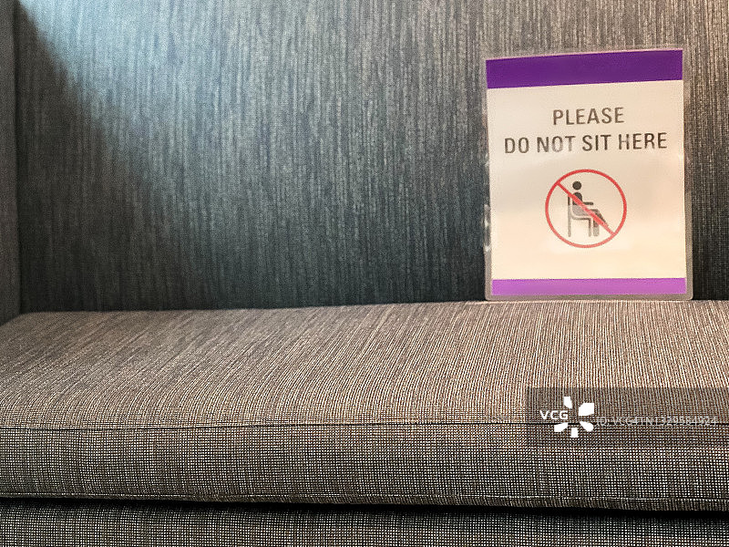 疫情常态化：候诊室沙发上保持社交距离的指示牌图片素材
