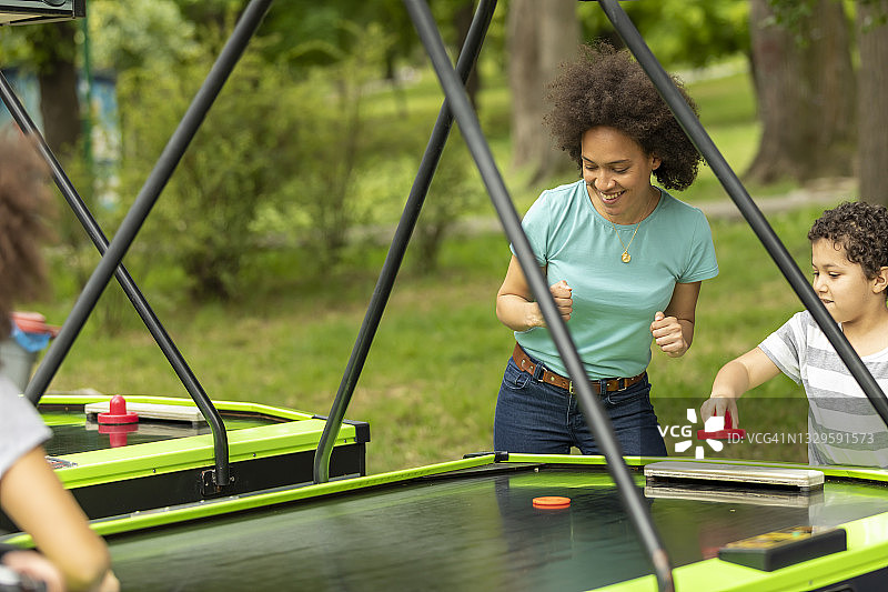 快乐的母亲和可爱的小儿子在娱乐公园玩耍图片素材
