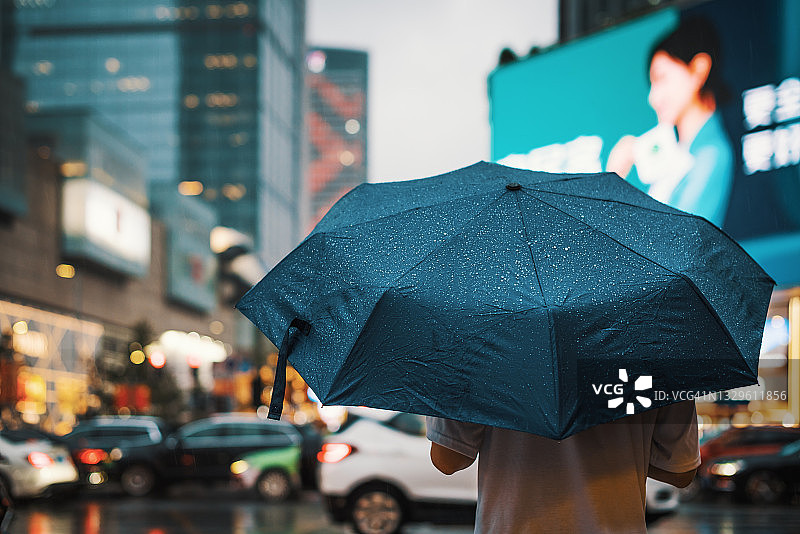 男人在城市里拿着雨伞图片素材