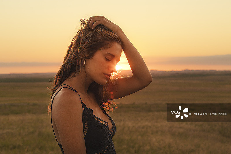 日落时分走在田野上的年轻女子特写图片素材