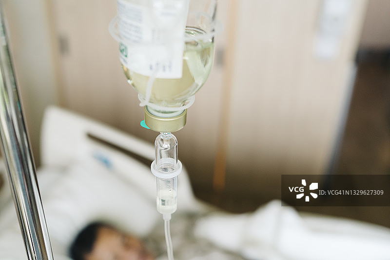 病人手部特写，连接着医疗输液管，躺在床上图片素材