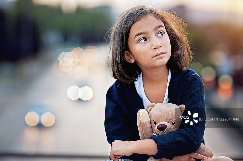 小女孩悲伤地站在桥上图片素材