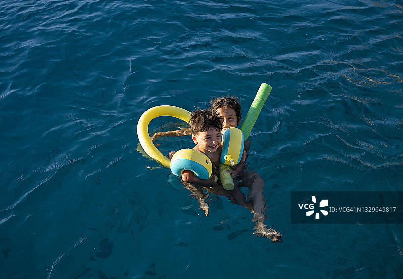 开心的兄弟姐妹在海里游泳图片素材