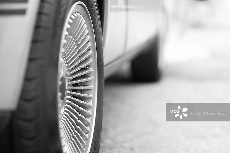 聚焦右轮毂和后轮的停放车辆图片素材