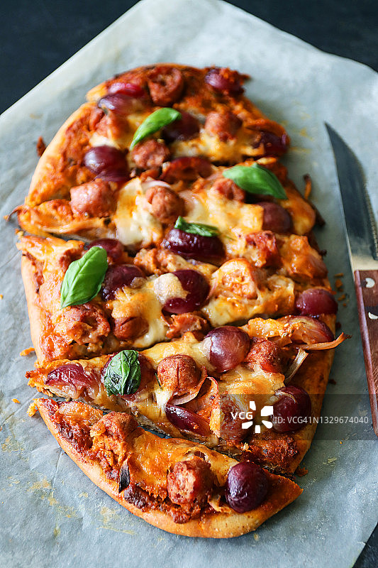 自制披萨：香肠、肉丸、葡萄、马苏里拉奶酪和罗勒叶图片素材