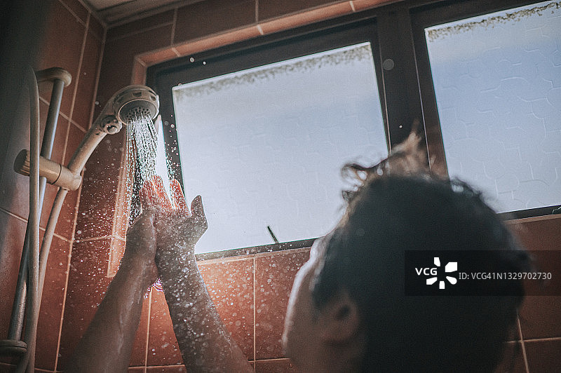 亚裔女性在浴室逆光下洗手图片素材