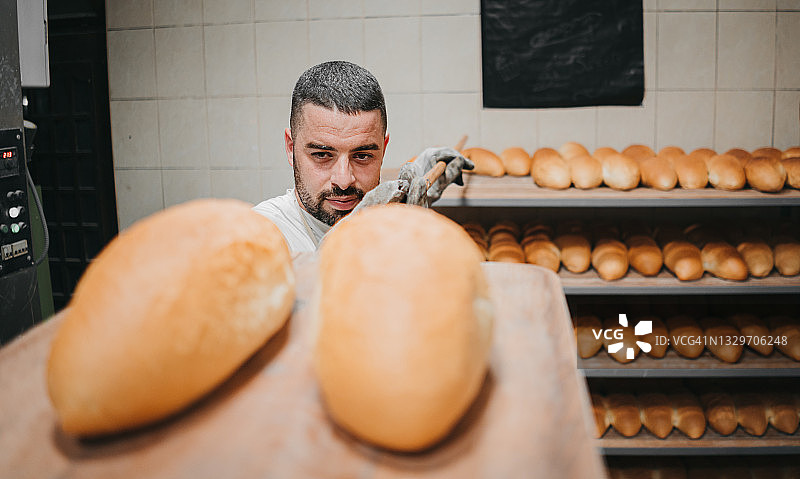 面包师在面包店展示烘焙好的面包图片素材