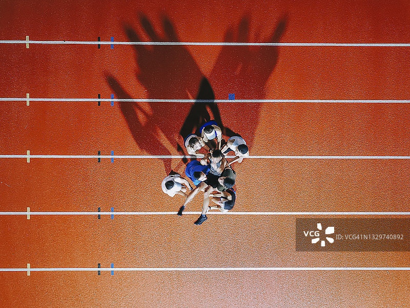 无人机视角：中国亚洲运动员欢呼雀跃，在体育场暴风云晚景中将获胜队长高高抛起图片素材