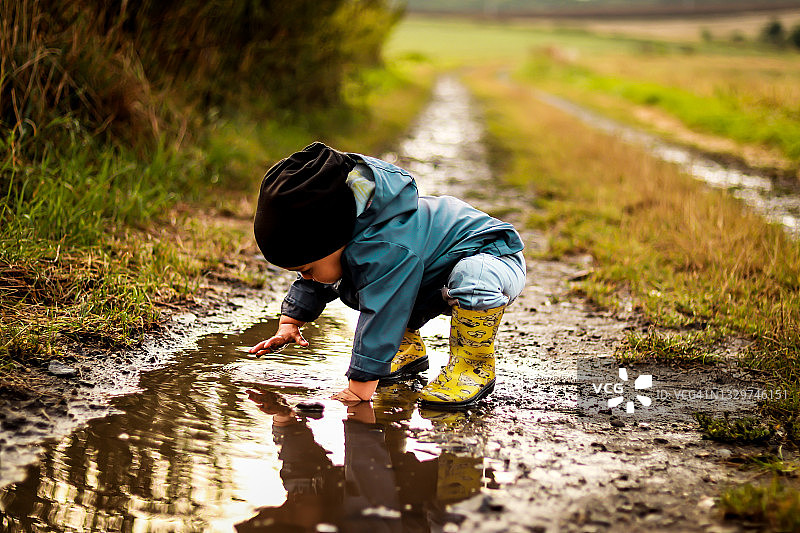 小男孩在水中跳跃图片素材
