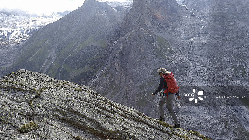 奋力攀登山脊的女人图片素材