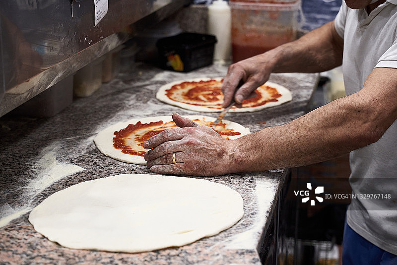 厨师在小餐馆准备新鲜披萨图片素材