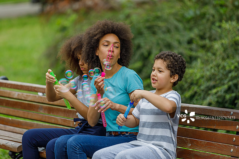 母亲在公园里和女儿、儿子共度美好时光图片素材