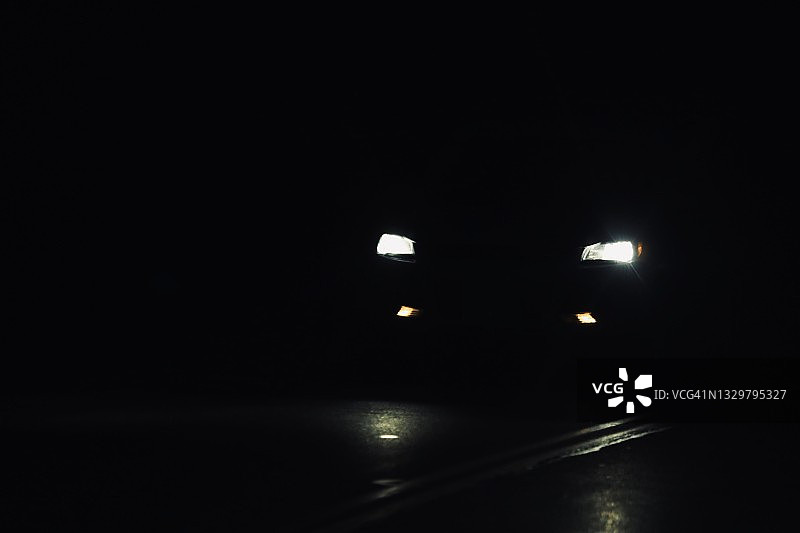 黑暗夜晚中的车灯图片素材