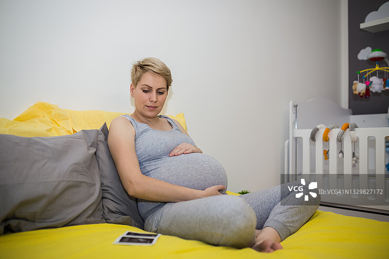 手持超声波扫描的匿名孕妇特写图片素材