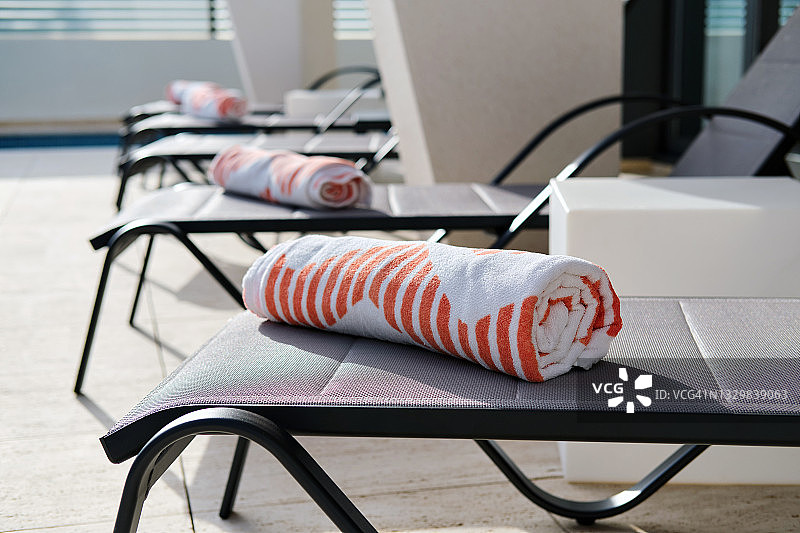 夏季露台上日光浴床上的折叠沙滩巾图片素材