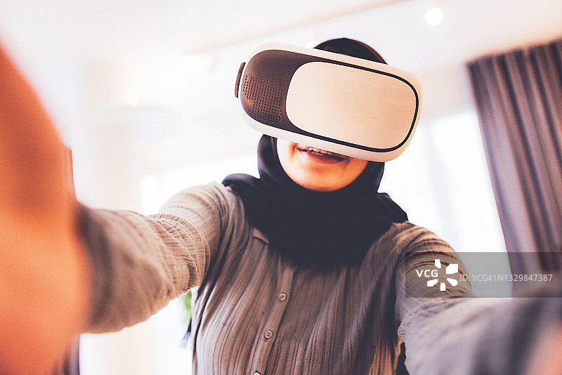 戴头巾的女孩享受VR体验图片素材
