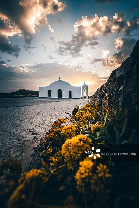海边的白色地中海教堂。日出，黄色鲜花，阿吉奥斯·尼古拉斯，扎金索斯，希腊图片素材