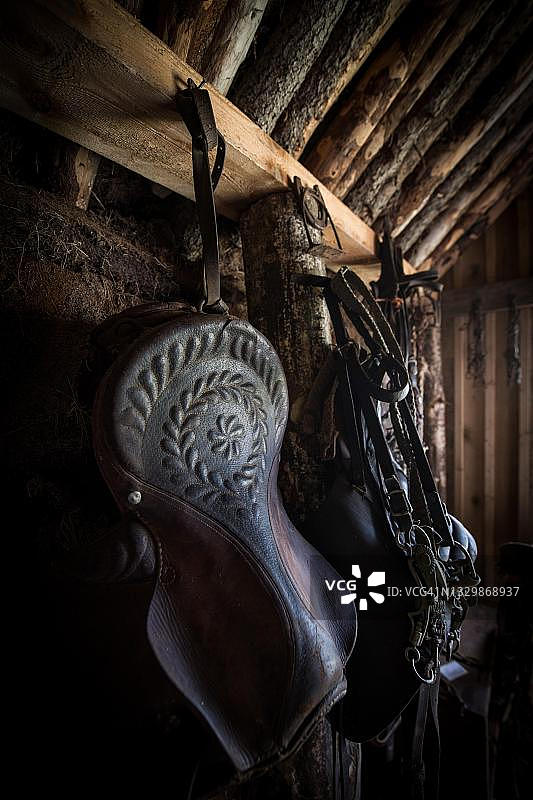 马厩里的旧装饰马鞍和缰绳，位于冰岛北部Lytingsstadir原始泥炭建筑中图片素材