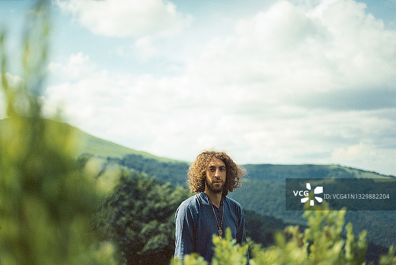 以绿山为背景的男人肖像图片素材