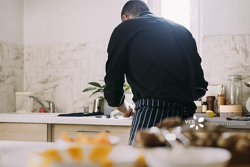 年轻男厨师正在准备美味佳肴图片素材