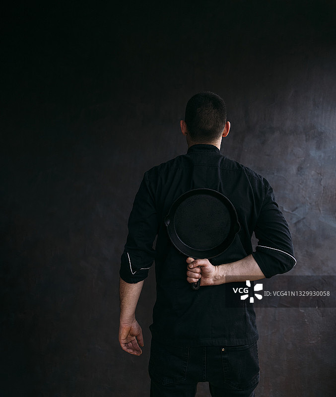 手拿煎锅的男厨师（影棚拍摄）图片素材