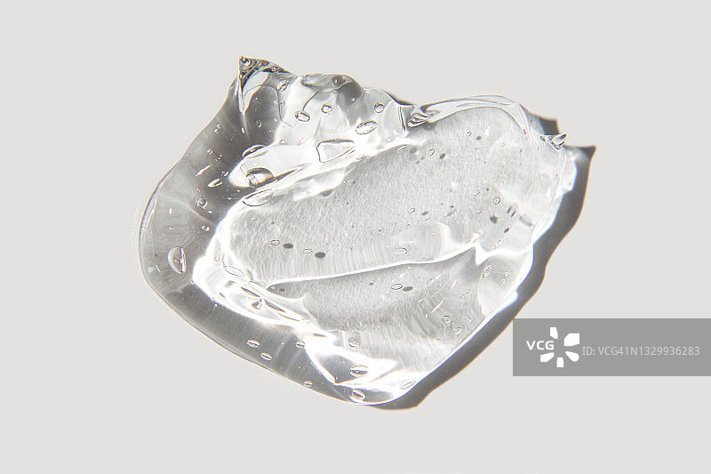 白色背景上的透明凝胶滴。透明质酸液体凝胶。平铺，俯视，复制空间图片素材