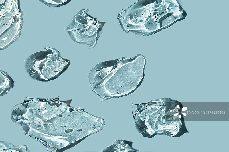蓝色背景上的透明凝胶滴，透明质酸凝胶图片素材