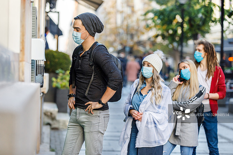 疫情期间在自动取款机前排队图片素材