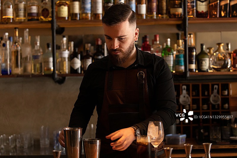在阿根廷布宜诺斯艾利斯酒吧工作的年轻酒保图片素材
