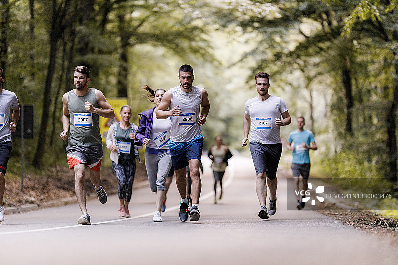 在沥青路上参加马拉松比赛的人群图片素材