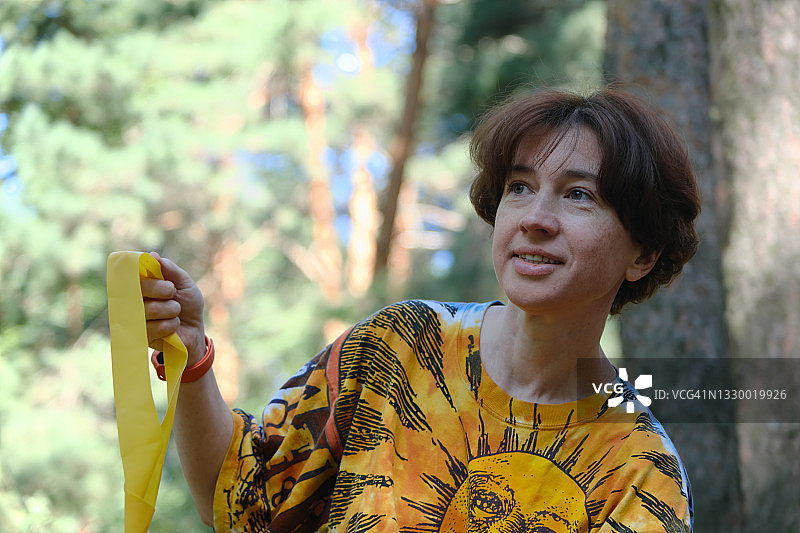 中年妇女在公园里用阻力带锻炼图片素材