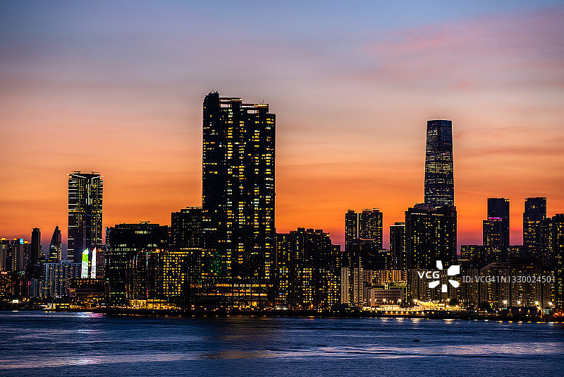 香港维多利亚港日落时分的城市景观和天际线图片素材
