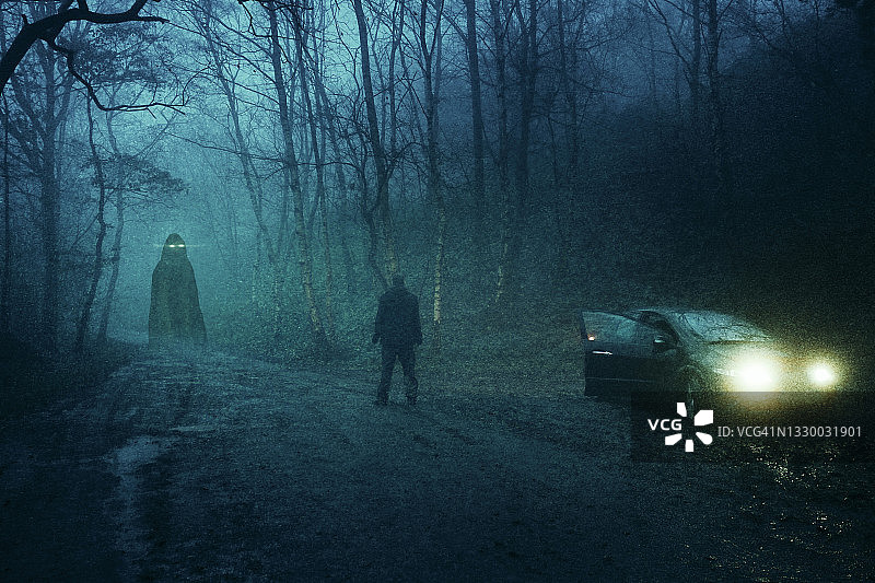 超自然概念：男子在冬季森林夜晚的汽车旁看着发光的鬼魂图片素材