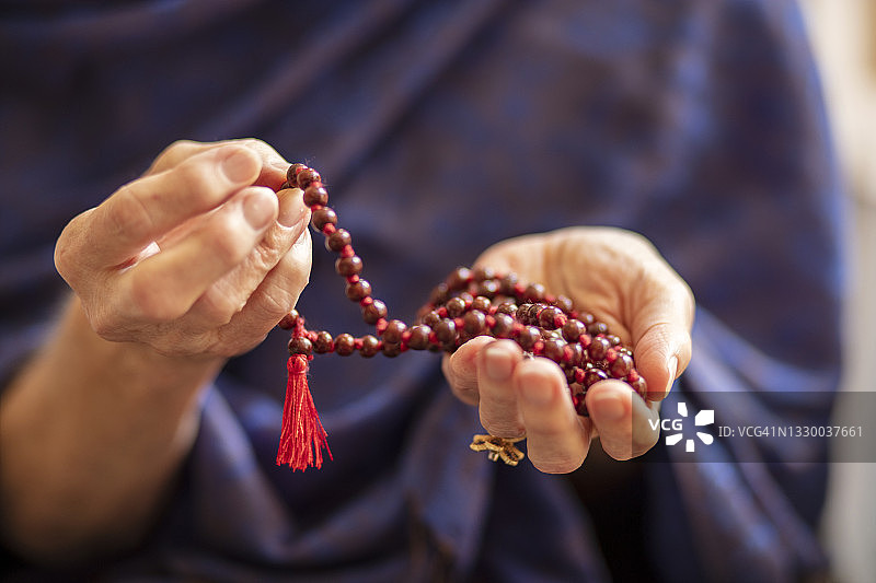 老年女性的手拿着佛教念珠图片素材
