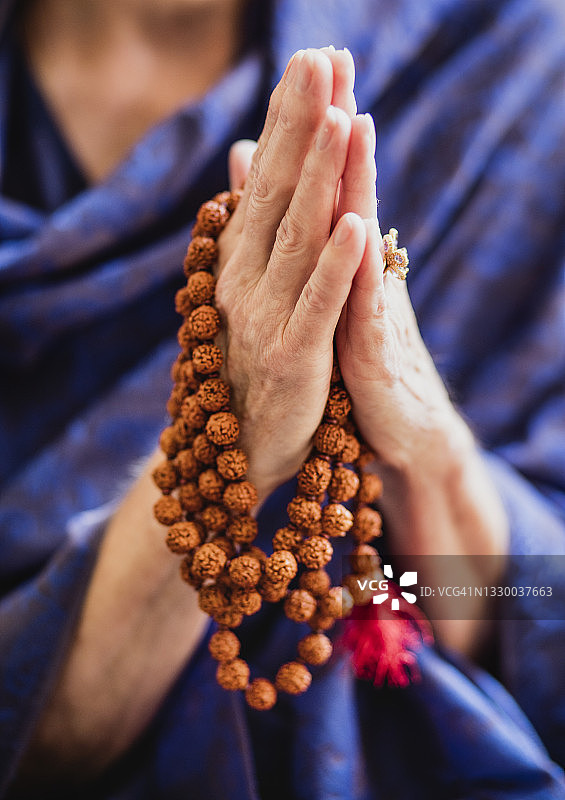老年女性的手拿着佛教念珠图片素材