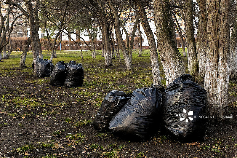 公园里装满垃圾的黑色塑料袋，清理城市垃圾，保护环境图片素材