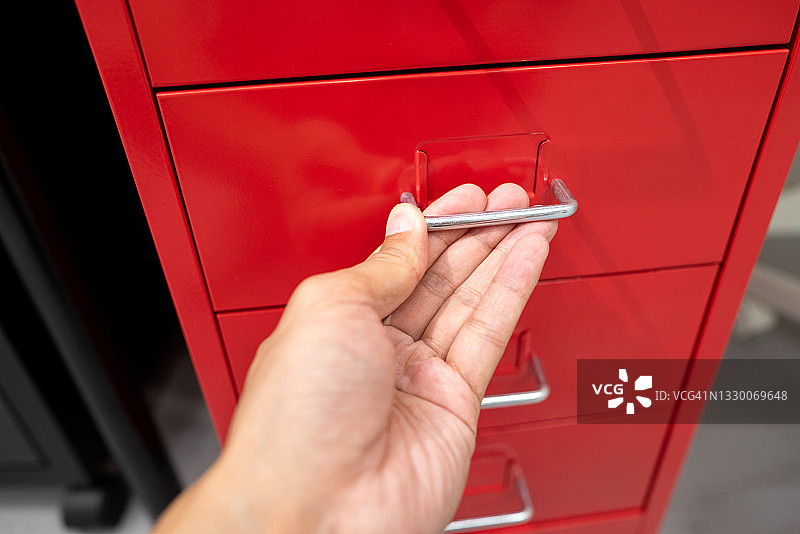 人手触摸红色抽屉把手图片素材