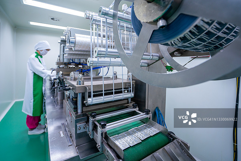 制药厂女工在制药工业制造厂操作生产线图片素材