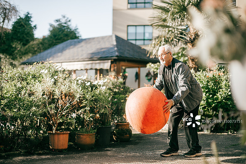用健身球锻炼的健壮老年男人图片素材