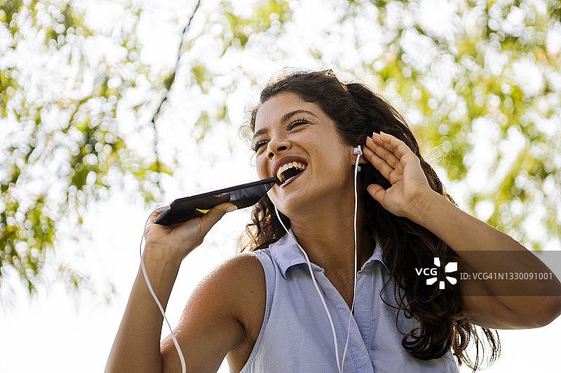 女人用智能手机听音乐图片素材
