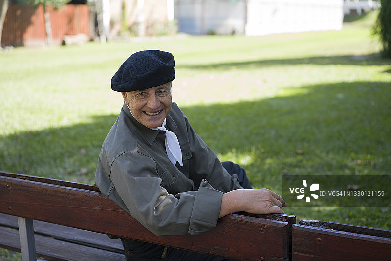 快乐的年长农民坐在生态农场的后院里图片素材