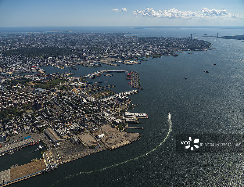 纽约史泰登岛、布鲁克林和韦拉扎诺海峡大桥的空中全景，哈德逊河上停泊着商业货船。图片素材