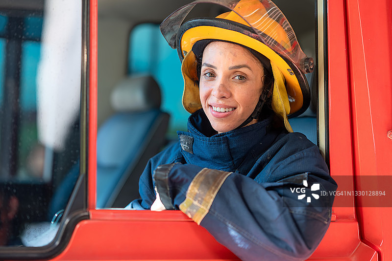 完成任务后在消防车上微笑的女消防员图片素材